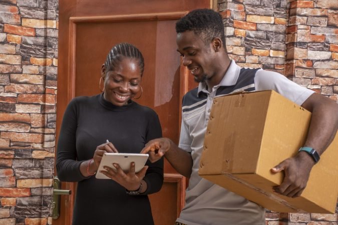 african-female-signing-proof-delivery-while-receiving-parcel-from-courier_181624-41714 african-female-signing-proof-delivery-while-receiving-parcel-from-courier_181624-41714